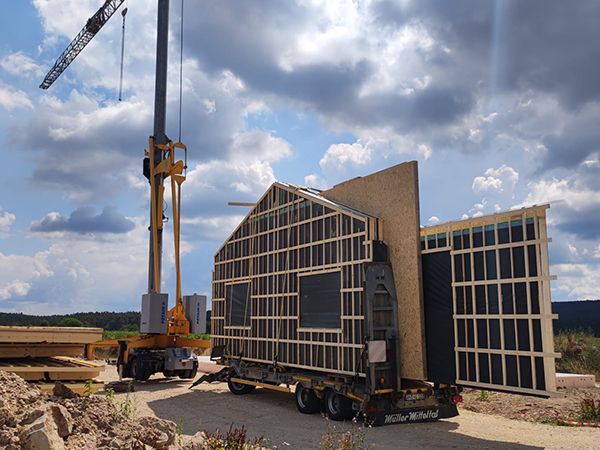 Holzwände einer Industriehalle werden mit dem Autokran angeliefert